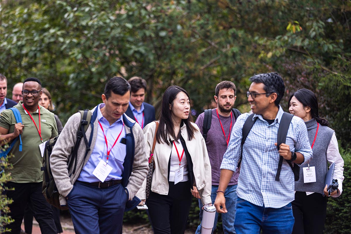 A group of delegates engage in discussion while walking between presentation spaces